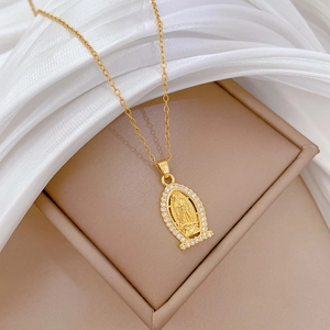 Close-up of golden oval portrait necklace with Virgin Mary relief and clear crystals