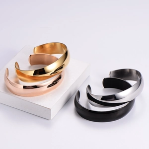 Detail of four C-shaped minimalist bangles in gold, rose gold, silver and black finishes