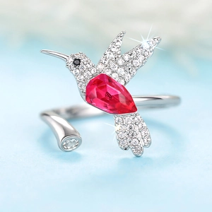 Macro-opname van kolibrie-ring met peervormige rode edelsteen en sprankelende diamanten