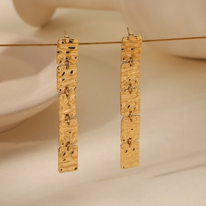 Detailed view of long gold tassel earrings featuring five textured square plates
