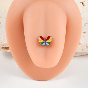Détail macro d'un piercing de langue papillon arc-en-ciel sur un modèle en silicone