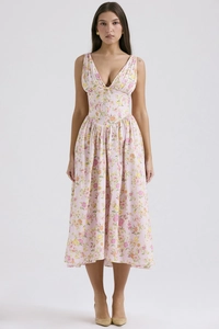 Detail of pink floral V-neck midi dress fabric and waist design on standing model
