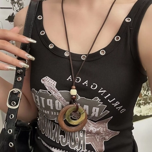 Detailed close-up of retro Zen ceramic necklace with wooden ring on black ethnic top