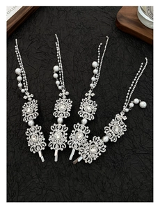 Detailed view of silver hair clips with pearls, rhinestones and elegant tassels