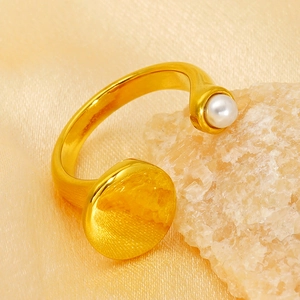 Minimalist gold plated open geometric ring with a white pearl and flat gold disc detail