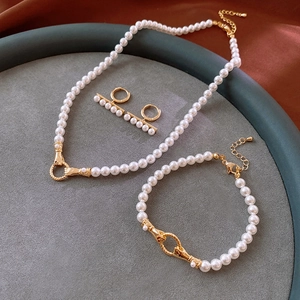 Elegant gold-plated pearl necklace and bracelet set in a grey display tray