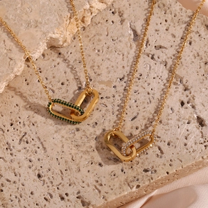 Detail of gold interlocking double rings with green and white zircon on a silk cloth