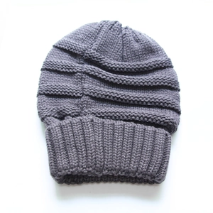 Detailed view of grey knitted beanie hat showing thick horizontal ribbed texture and wide cuff