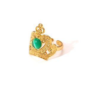 Detail of a gold crown ring featuring a green cat-eye stone and adjustable band