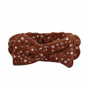Detailed texture of brown plush headband featuring silver star prints and large bow