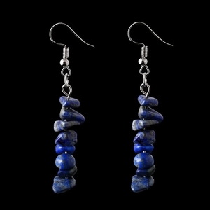 Detailed macro view of natural blue lapis lazuli stone beads on silver hook earrings