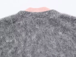 Detail of pink ribbed crewneck and grey faux mohair knit texture for women's sweater