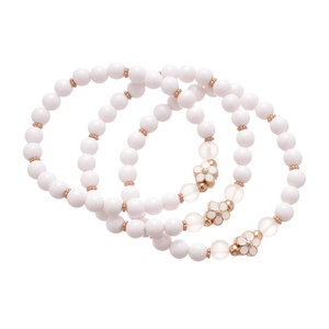 Three-piece set of elegant beaded bracelets with white enamel flower charm and rose gold beads