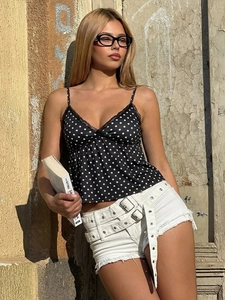 Top a pois con pizzo e pantaloncini di jeans con cintura a doppia fibbia