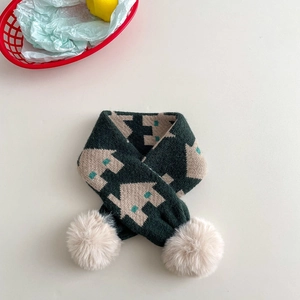 Detailed knit texture of green winter scarf with house patterns and plush pompoms
