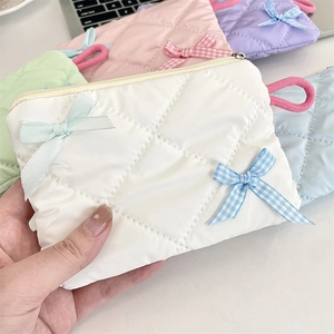 Quilted bow makeup bag in pastel colors featuring a metal zipper and carry handle