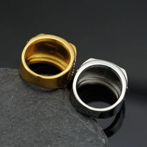Detail of wide chunky gold and silver titanium rings with micro diamonds on textured stone