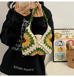Detail of handmade crochet shoulder bag featuring sunflower patterns and woven green strap
