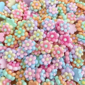Close-up of colorful resin flower beads in pastel candy tones for DIY nail art and crafts