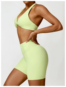 Detail of light green yoga set with twisted halter sports bra and high-waisted shorts