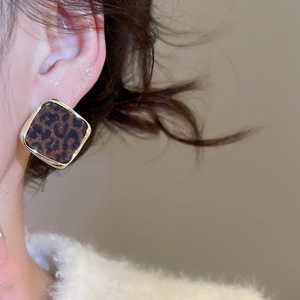 Détail d'une boucle d'oreille carrée léopard avec texture velours et bordure dorée