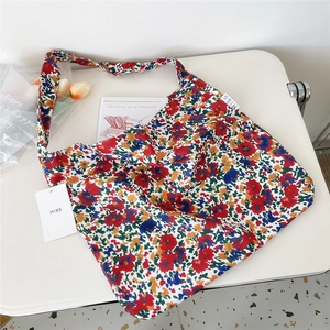 Detailed close-up of a floral canvas tote bag with a white MISS brand tag and woven label