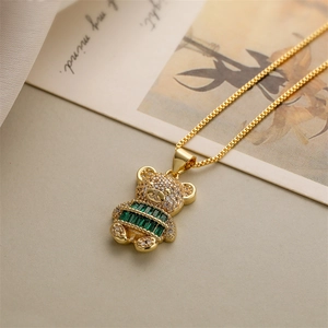 Close-up of golden bear pendant with sparkling crystals and green emerald zircon