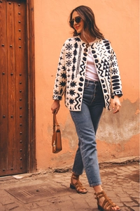Dettaglio di giacca vintage con motivi geometrici, scollo rotondo e tasche donna