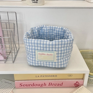 Close-up of blue plaid quilted fabric storage basket with Sozakka Studio woven label