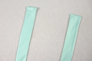 Detailed close-up of mint green satin halter neck straps with clean stitching on fabric