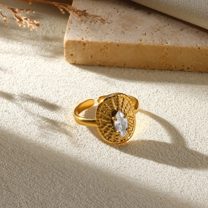 Macro view of gold flower ring with center crystal and granular textured details