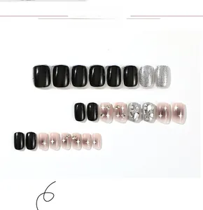 Detail view of black gloss, silver glitter, and rhinestone starburst press-on nails