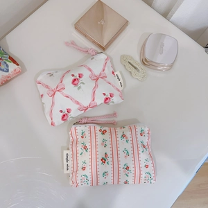 Pink floral cotton makeup pouches with ribbon bow and zipper, organized on clean surface