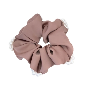 Chouchou élégant en satin rose poudré avec perles blanches sur fond blanc pur