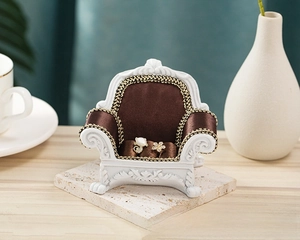 Detailed view of a mini vintage sofa jewelry display stand holding luxury earrings