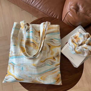 Detail view of cotton tote bag and matching scrunchie with artistic ink marble print