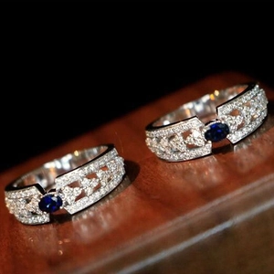 Elegante anello in argento con zircone blu zaffiro e pavé di diamanti e design cavo