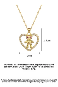 Close-up of golden heart bear pendant with white zircon pavé and red gemstone eyes