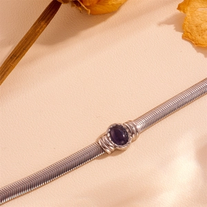 Macro shot of silver snake chain bracelet with a deep purple cat eye stone detail