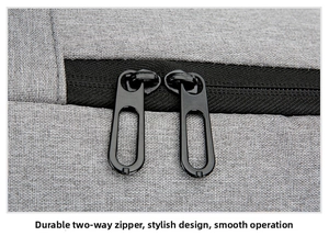 Detailed close-up of durable dual metal zippers on a gray business laptop backpack