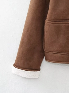 Detailed view of brown suede jacket cuffs and white faux shearling lining and pockets