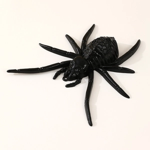 Black LED Halloween spider prop with plastic web pattern and glowing eyes on a white background