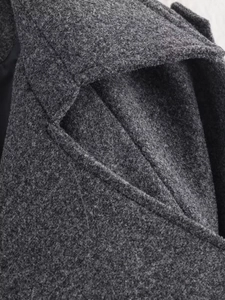 Detail view of lapel and epaulettes on heavy dark grey wool blend overcoat with stitching