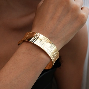 Détail du bracelet manchette doré géométrique avec grains texturés et rayures polies