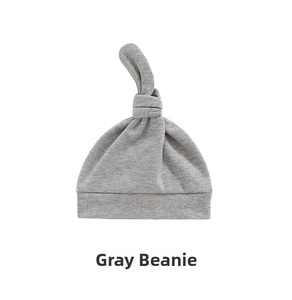 Detail of soft grey knotted cotton baby hat with folded brim on a white background