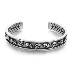 Bracelet jonc style punk gothique en acier titane argenté avec reliefs de crânes détaillés