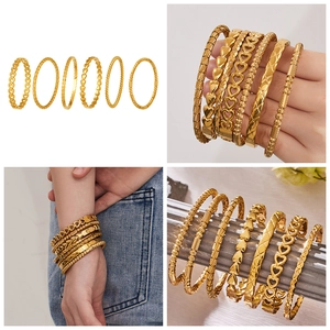 Detailed view of 6-piece gold stacked bangle set with heart and geometric patterns