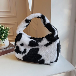 Detail of the cow print plush handbag with soft faux fur texture and top zipper closure