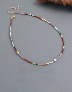 Détail d'un collier de perles multicolores avec fermoir mousqueton doré et chaînette