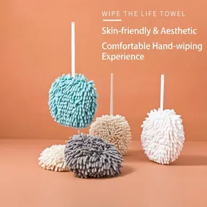 Absorbent chenille ball hand towels in multiple colors with hanging loops on orange backdrop